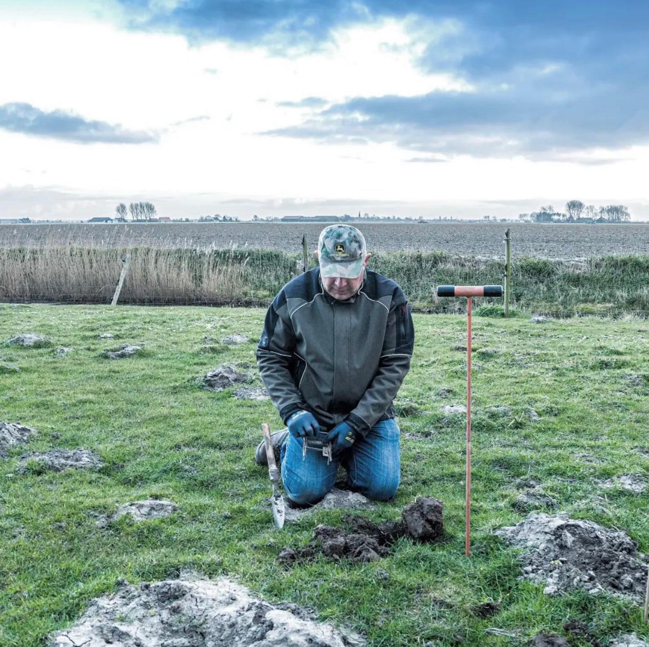 Aart Koppert aan het werk in een weiland